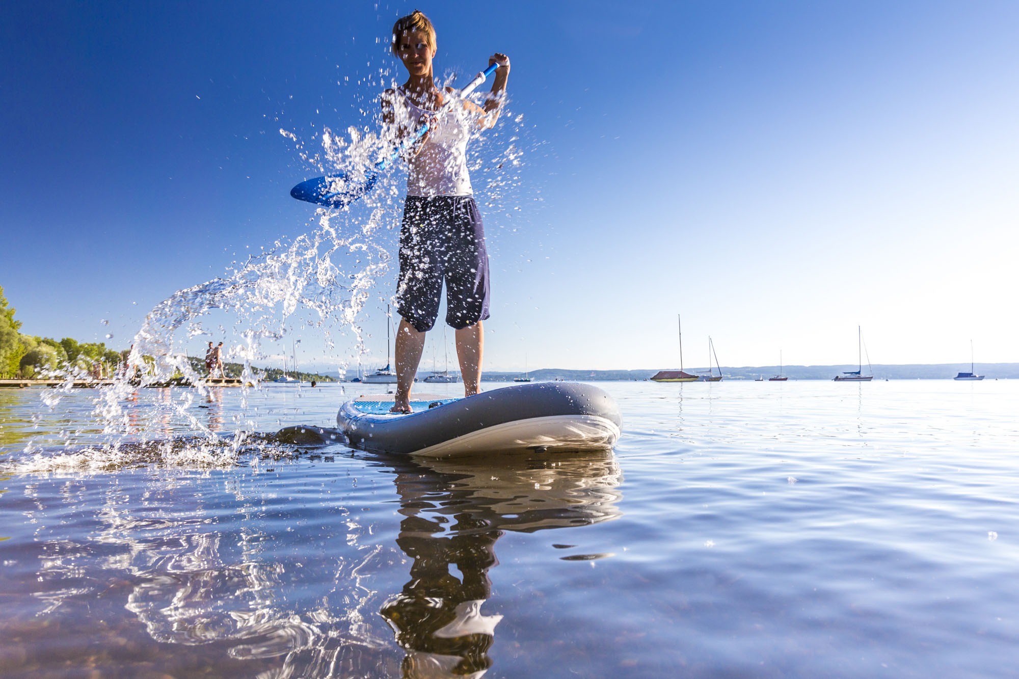 Woman paddleboarding in the lake Ammersee, Bavaria, Germany